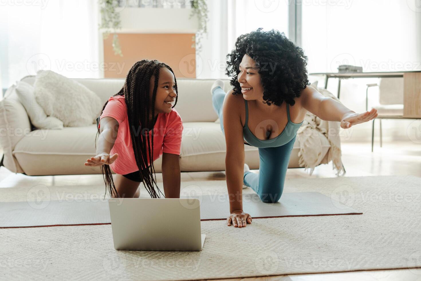 Mother and daughter doing online fitness at home photo