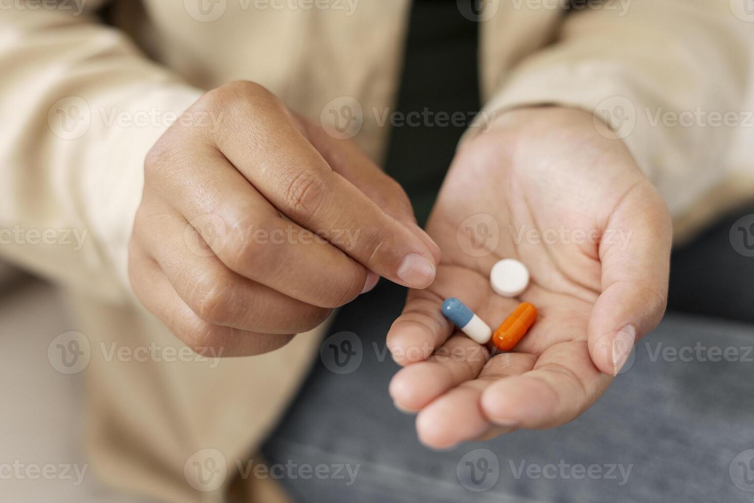 Woman holding medicine pills in hand getting ready to take prescription medicine photo