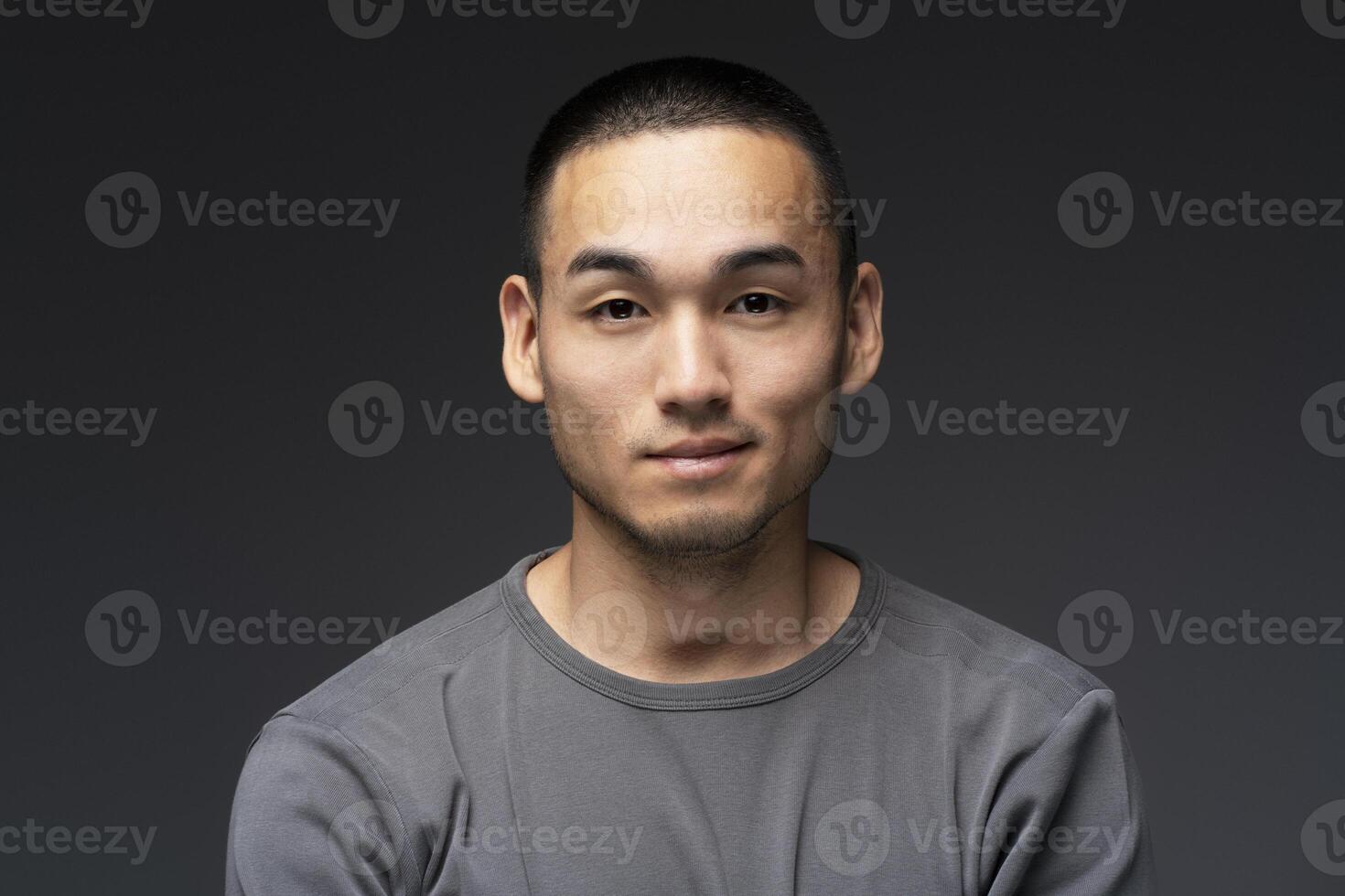 Young asian man posing on dark background photo
