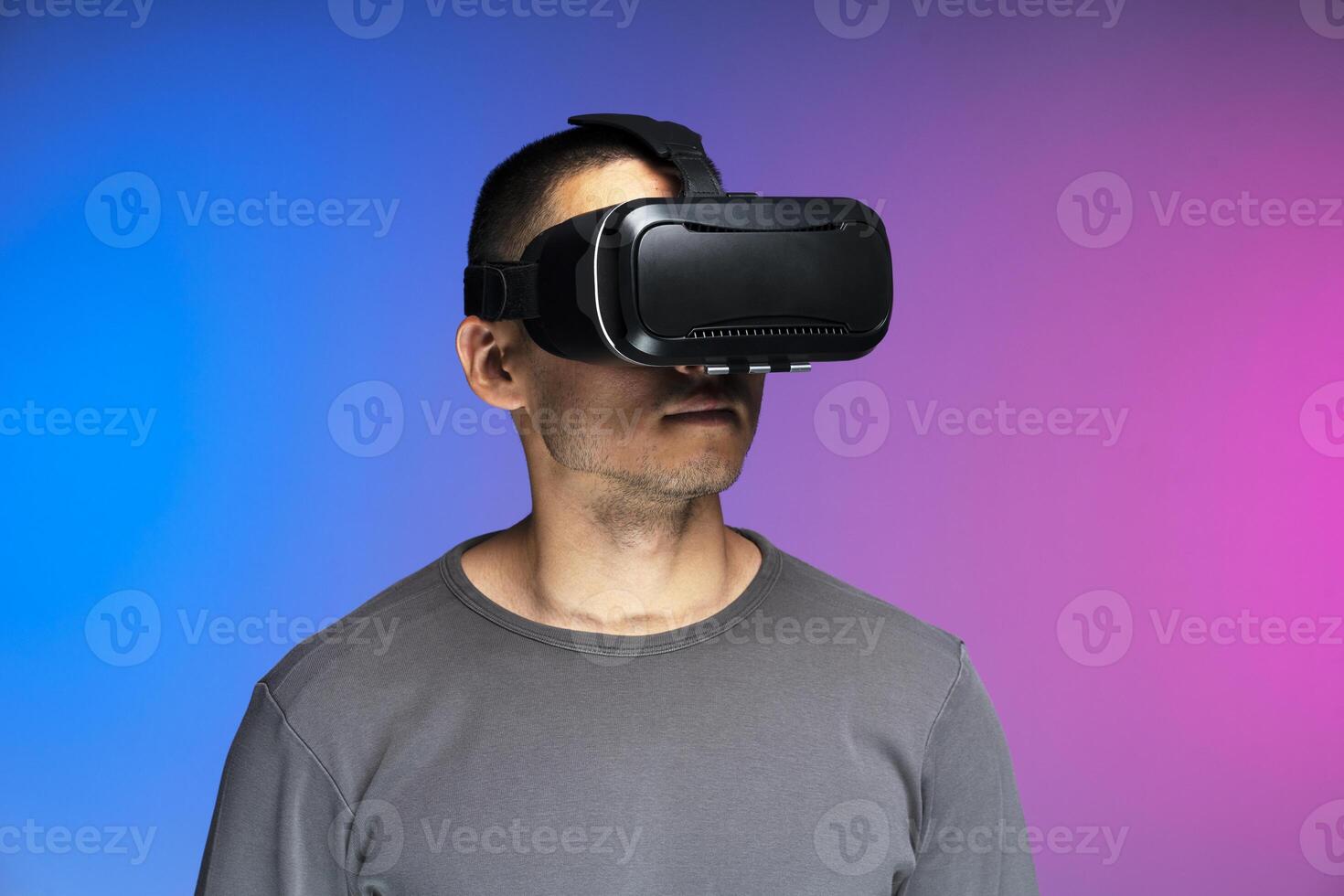 Man experiencing virtual reality using headset on gradient background photo