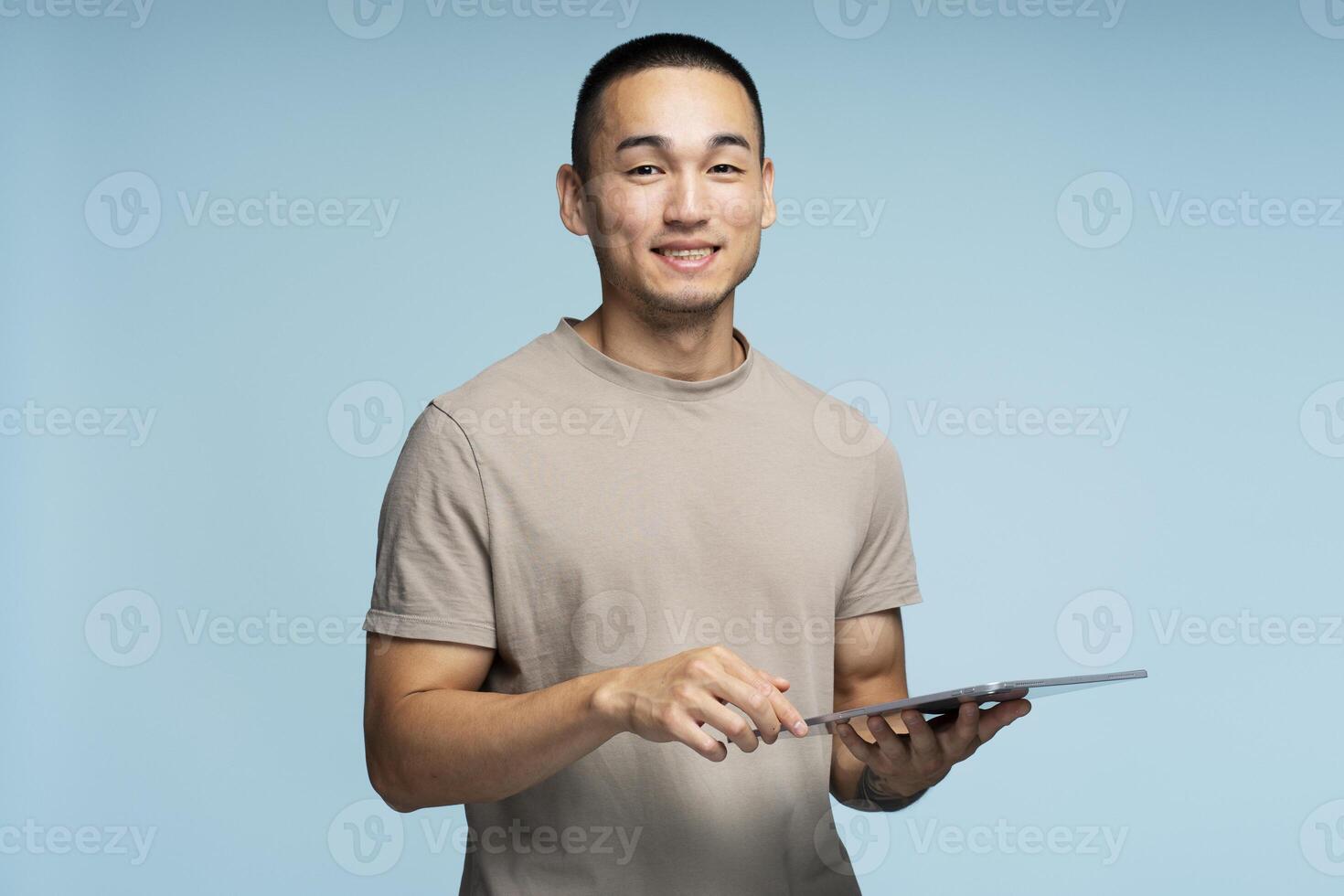 Asian man smiling using digital tablet on blue background photo