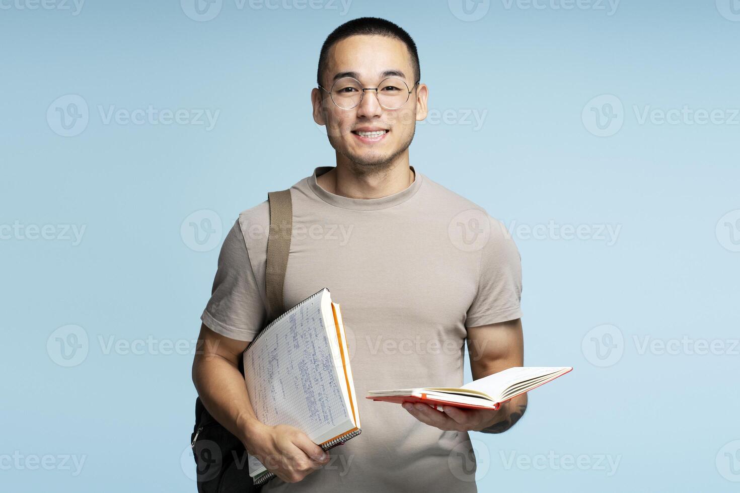 Young student smiling holding books and wearing backpack photo