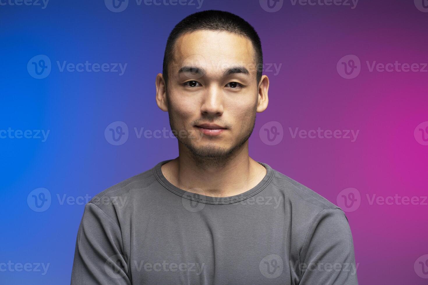 Young adult man posing with neutral expression on colorful background photo