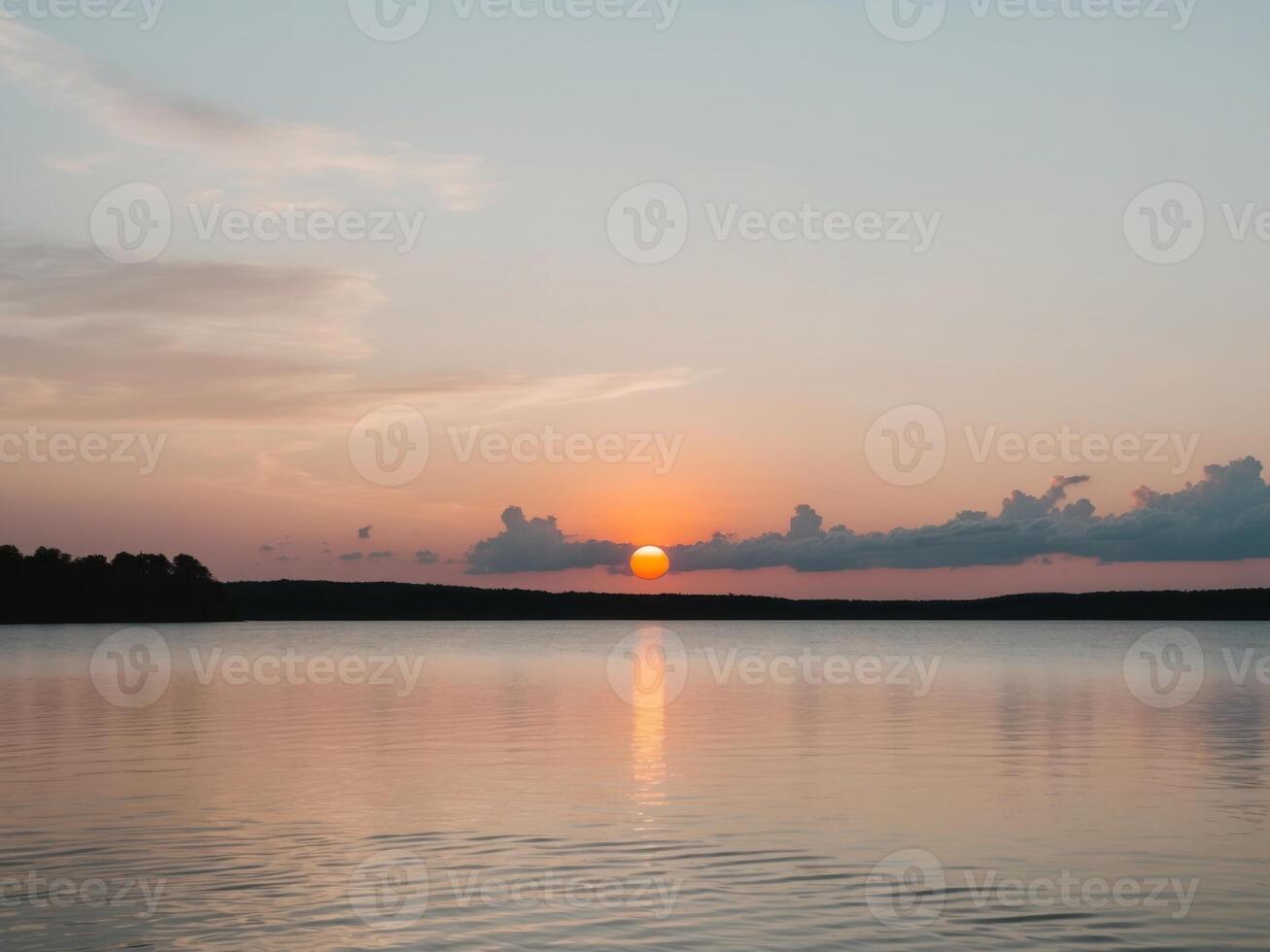 A sunset over a lake with a body of water in the background photo