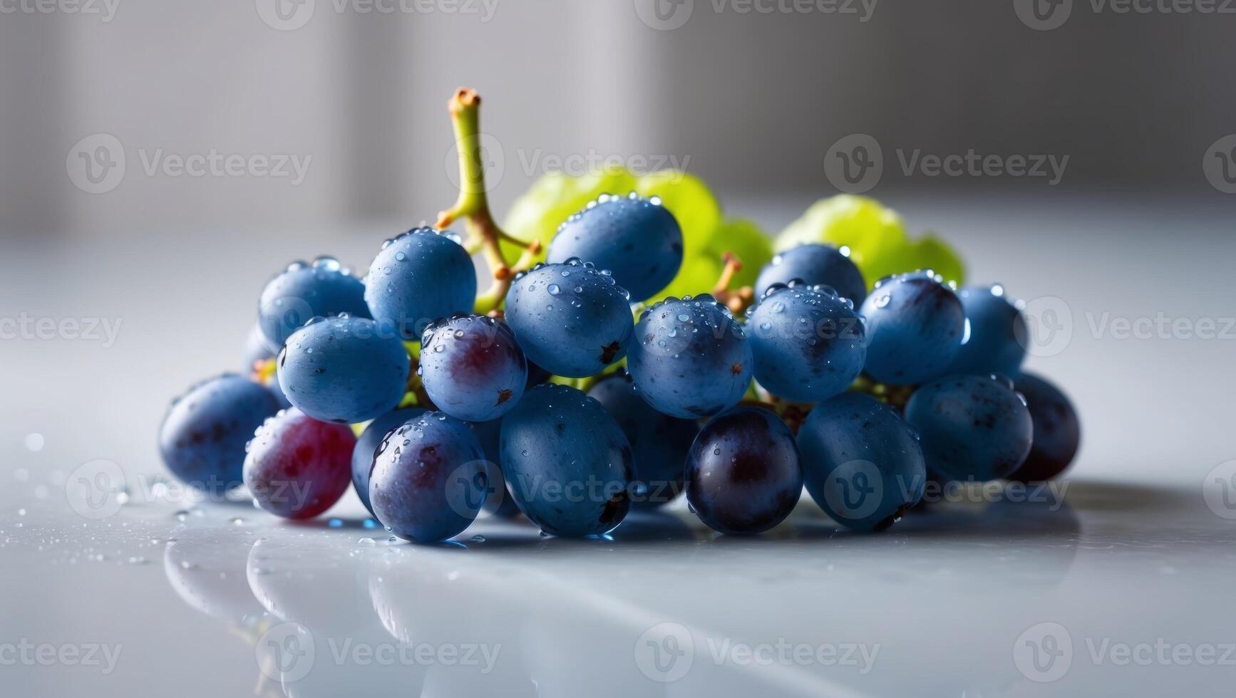 A bunch of grapes on a table with water droplets photo