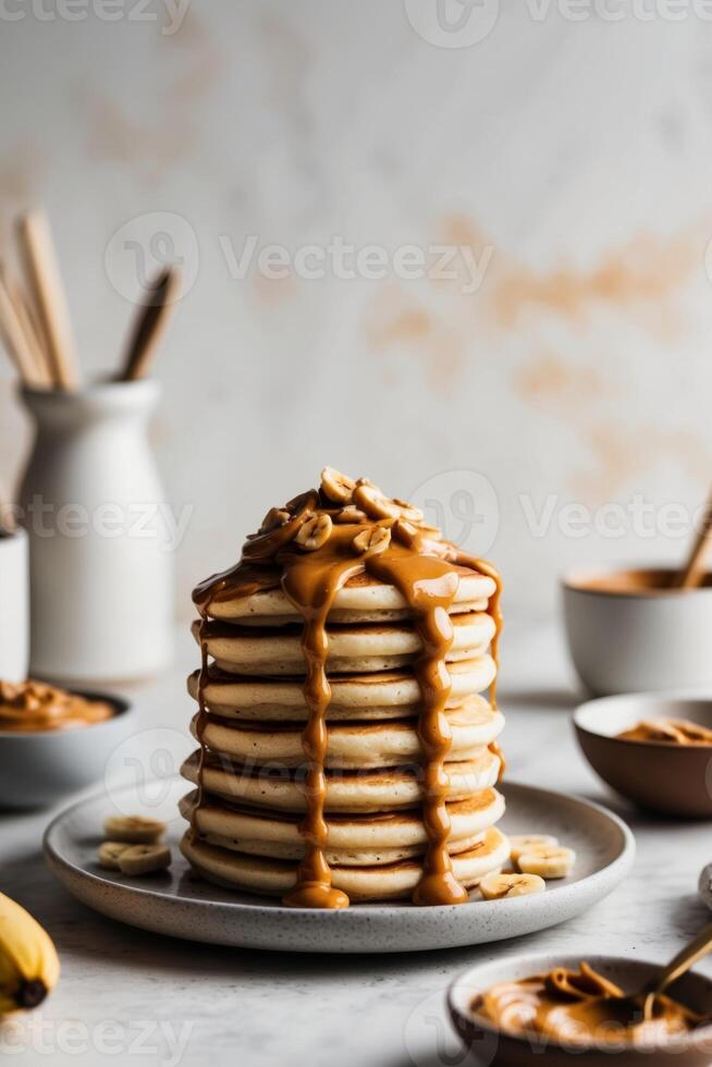 A stack of pancakes with peanut butter and bananas photo