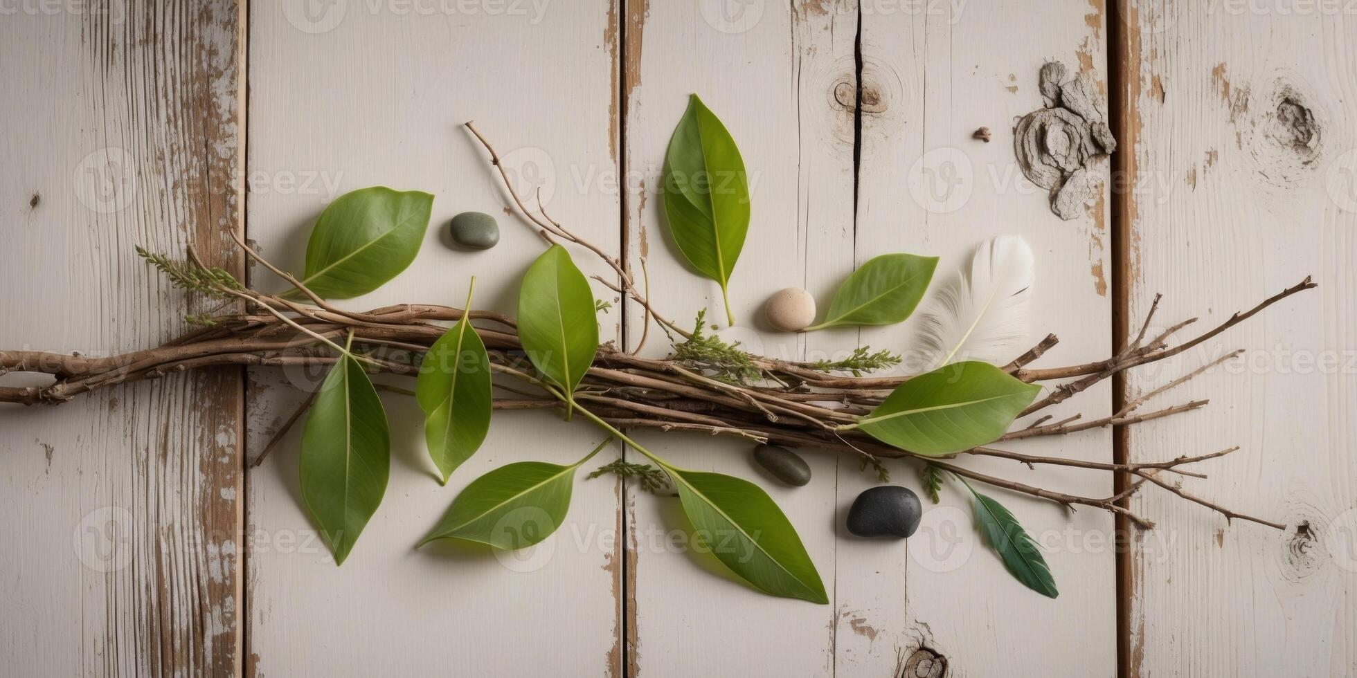 A branch with leaves and stones on a wooden background photo