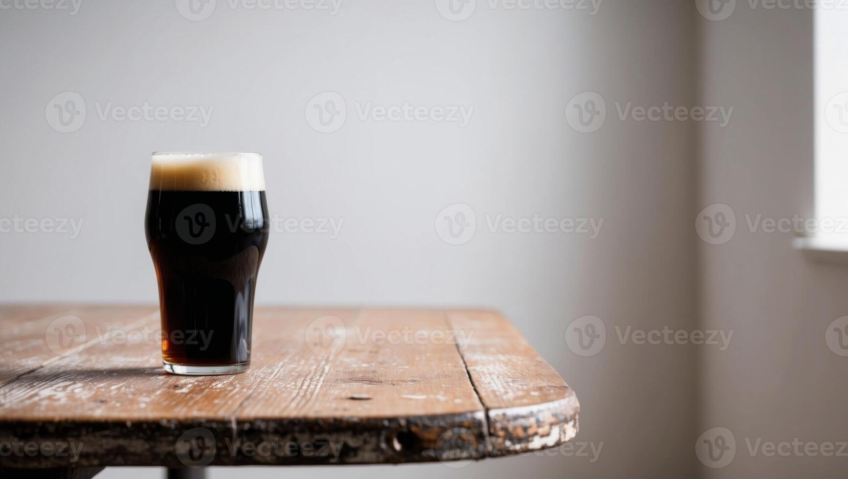 A glass of dark beer sitting on a table photo