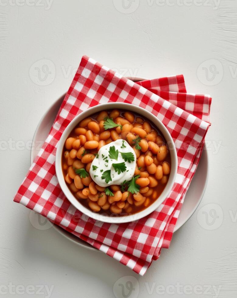 Baked beans with sour cream on a white table top view photo