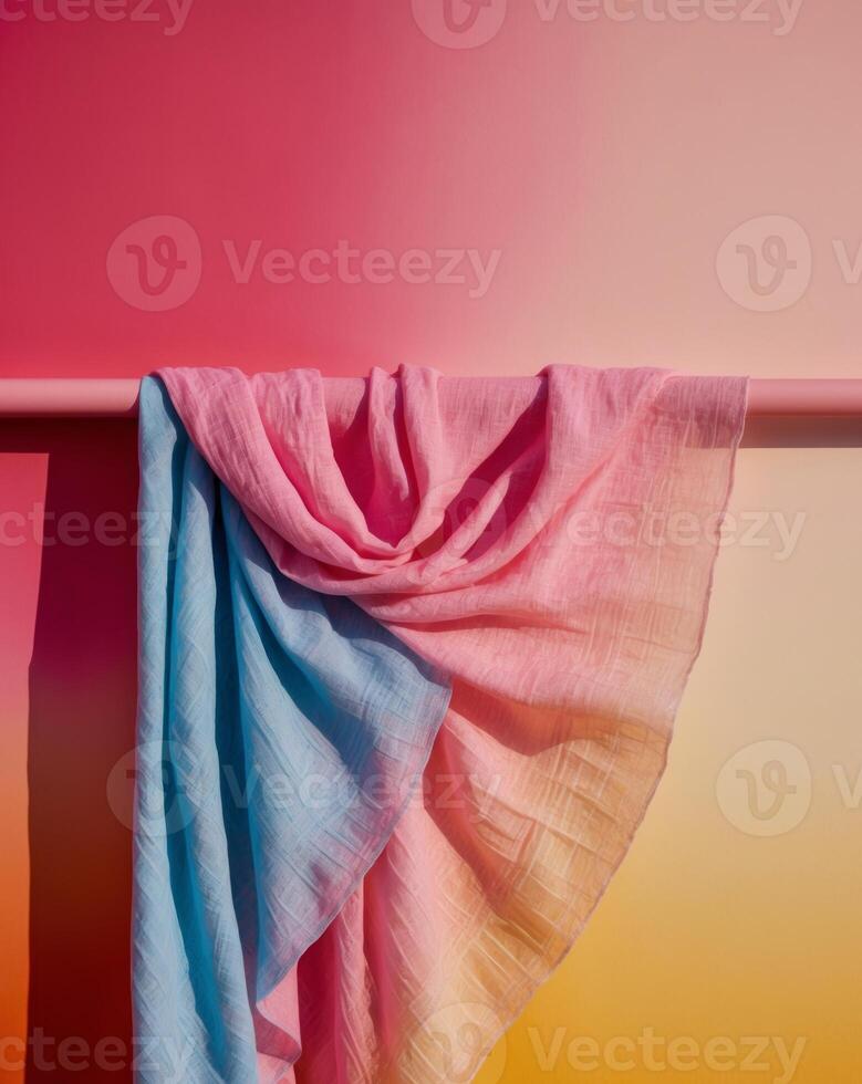 A pink and blue scarf hanging on a pole photo