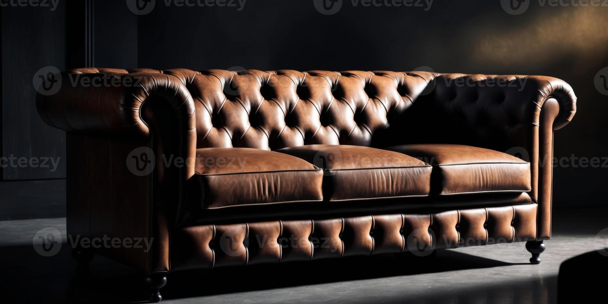 A brown leather couch in a dark room photo