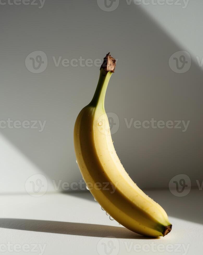 A banana is shown on a white surface photo