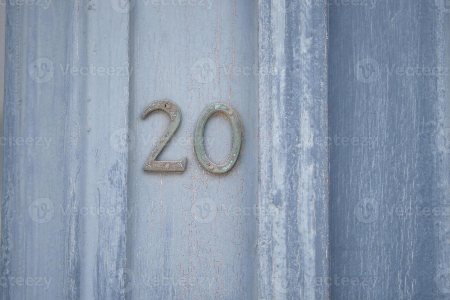 A weathered, rustic wooden door showcasing the number 20 in a charming and decorative style photo