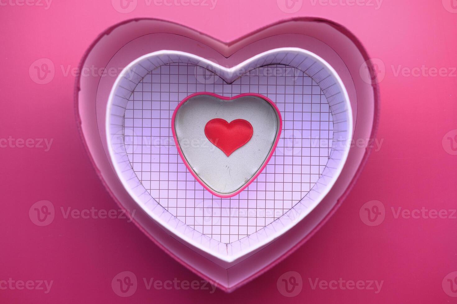 Vibrant and Colorful HeartShaped Decorative Boxes Displayed on a Soft Pink Background photo