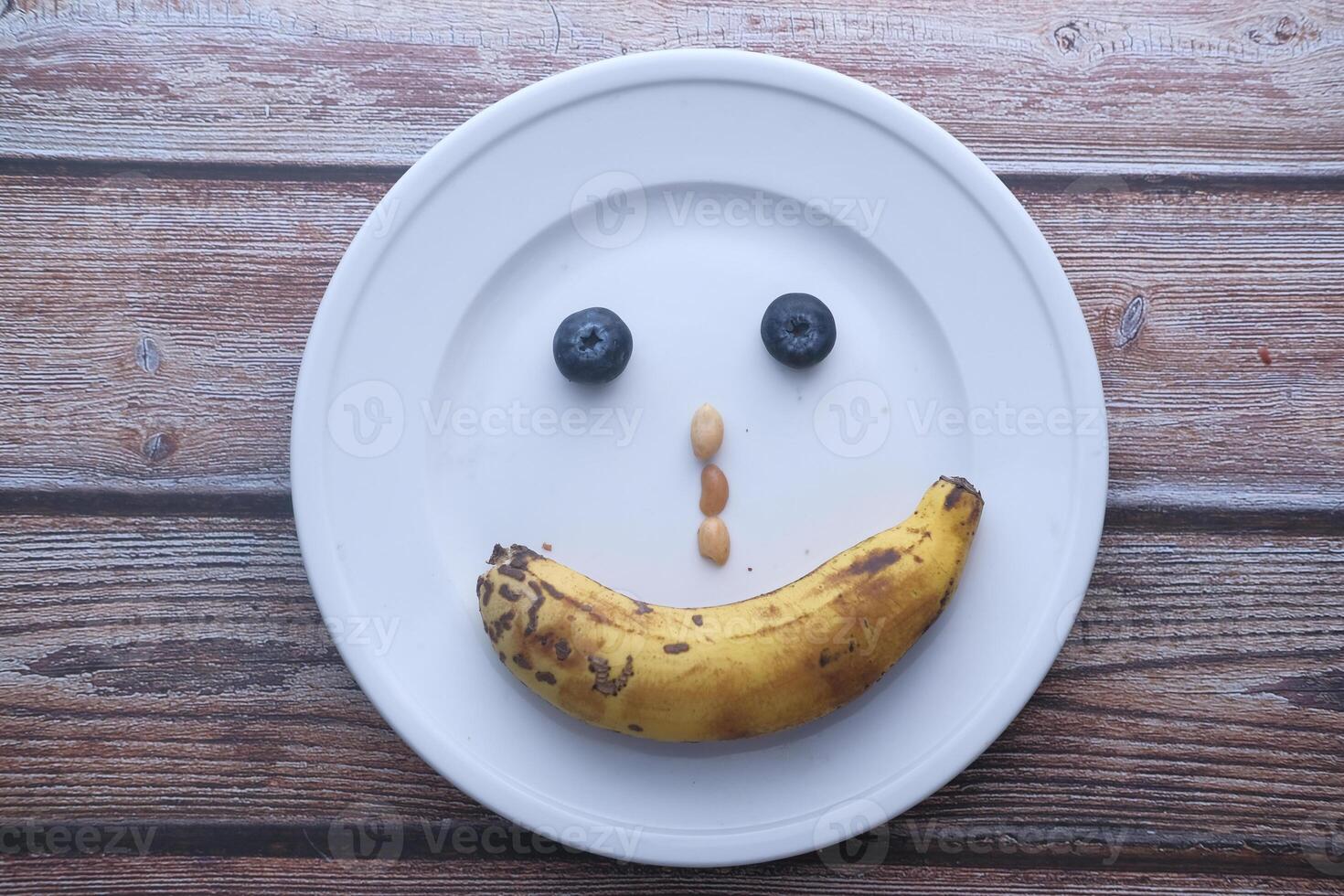 Creative Food Art A Smiley Face Plate Design Featuring Banana and Various Berries photo
