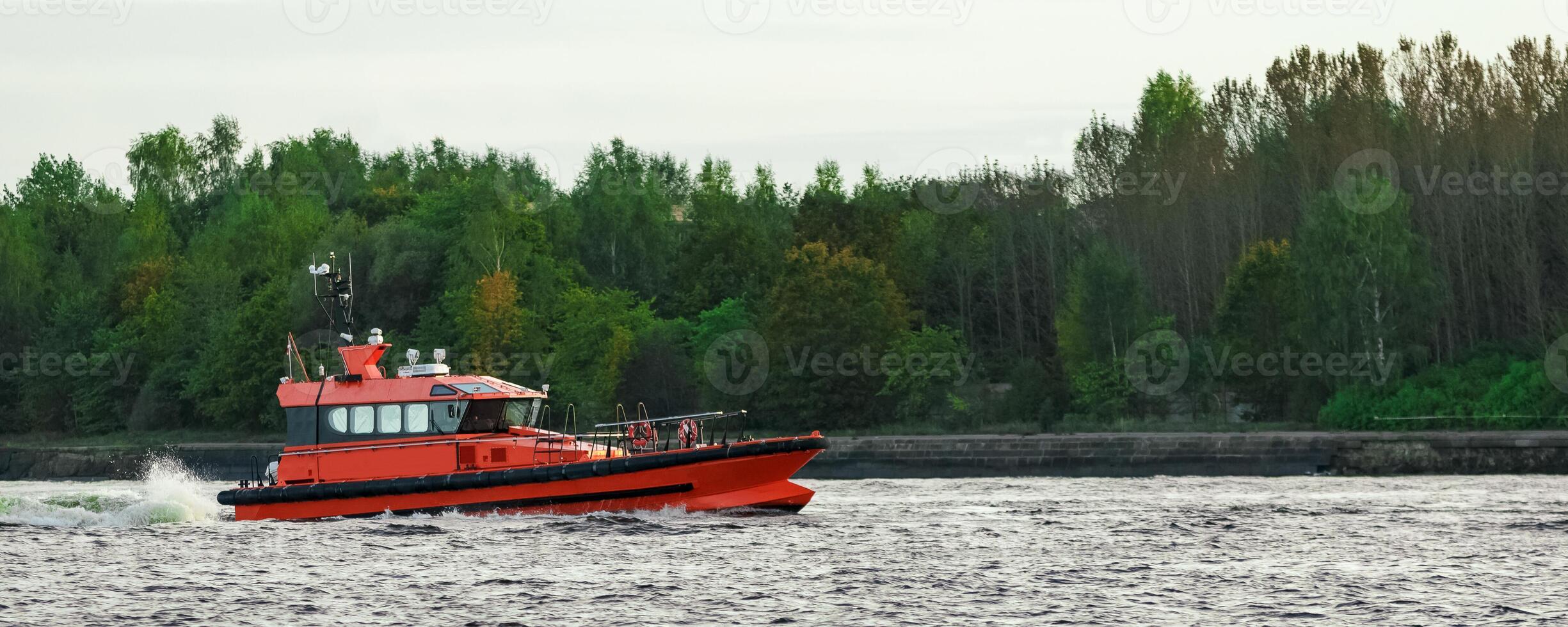Orange pilot ship sailing on the Daugava river photo