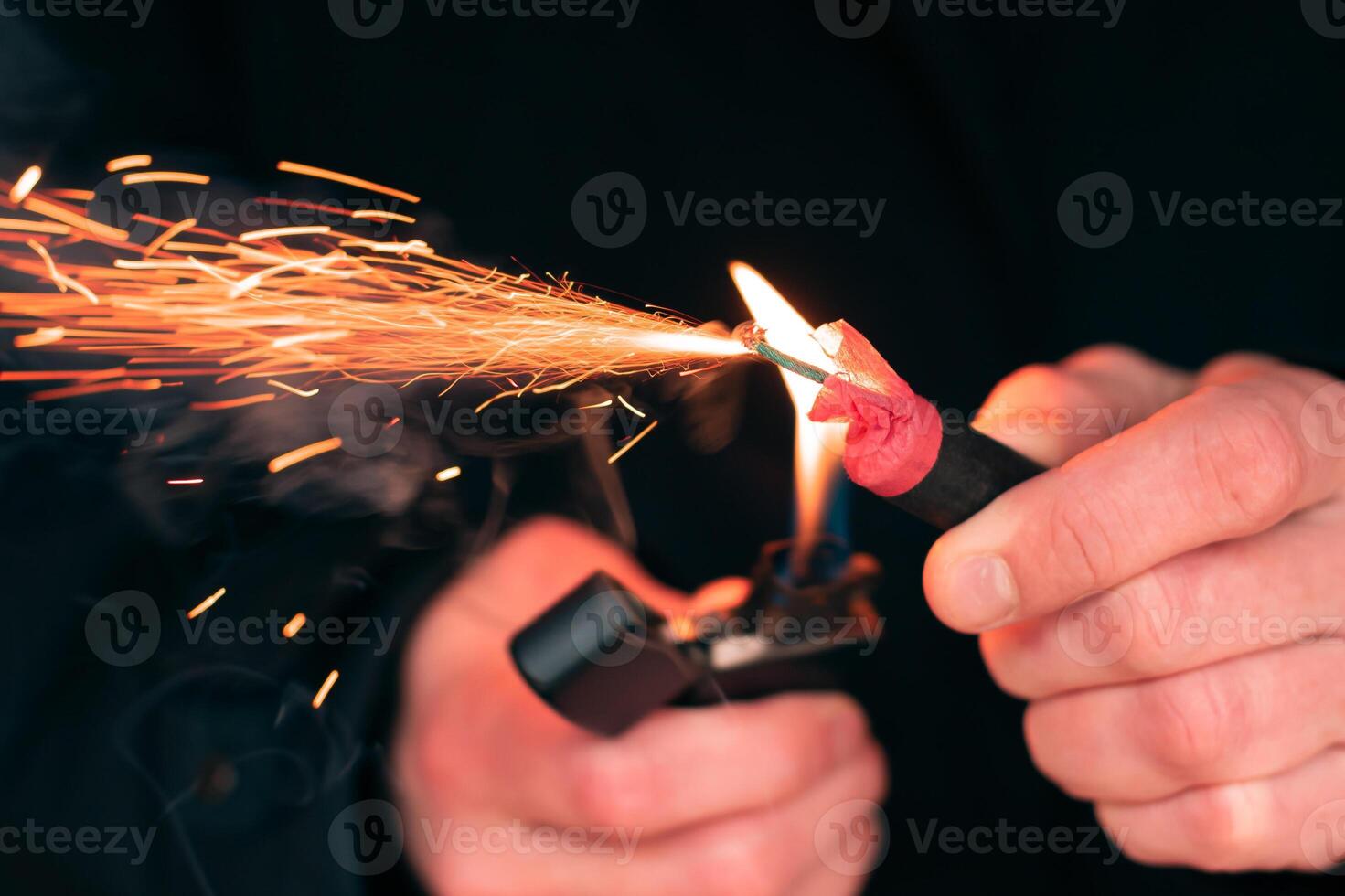 The Firecracker in a Hand. Man Holding a Burning Petard in His Hand. A Human with a Pyrotechnics that Burns with Sparks and Smoke Outdoors photo