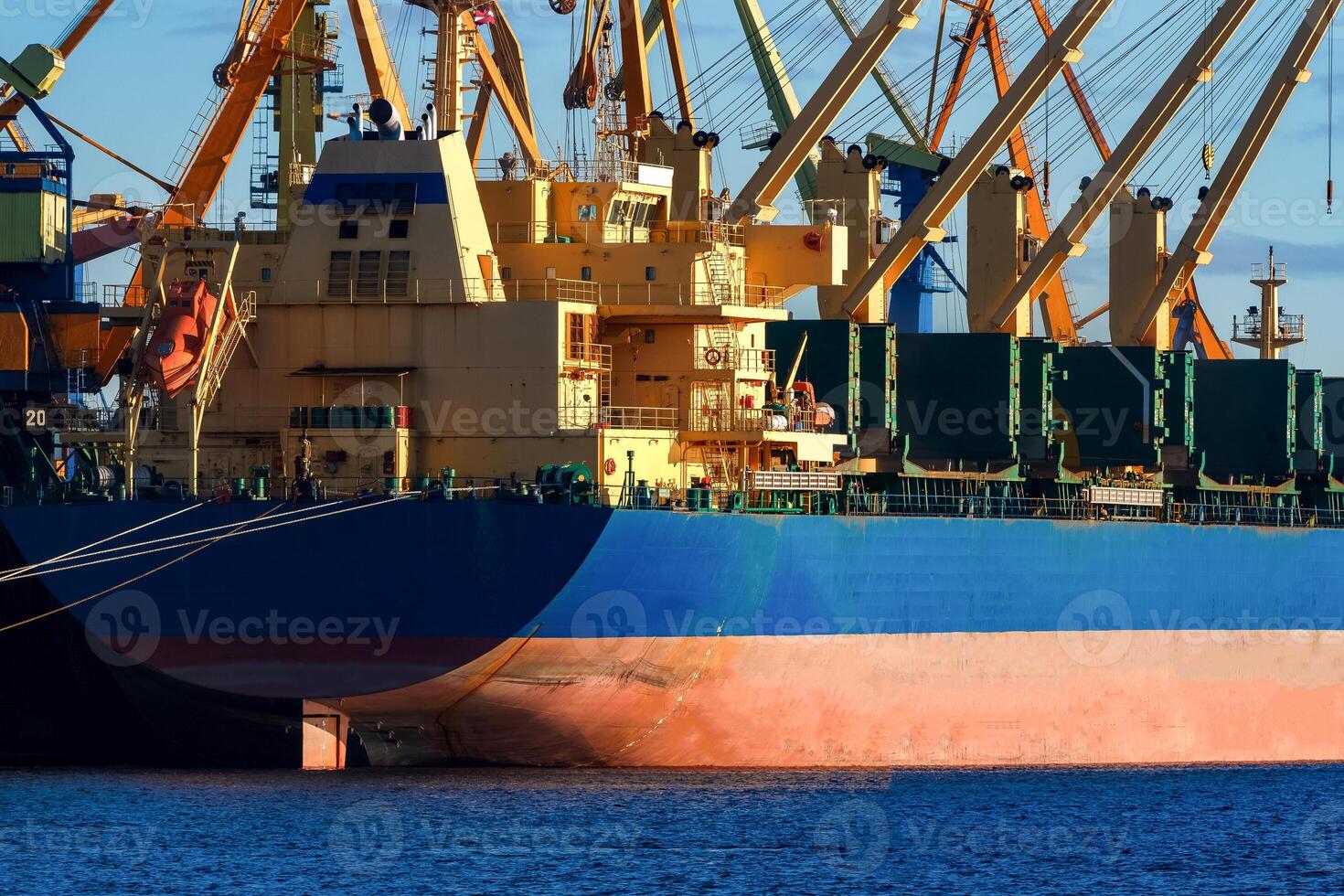 Blue cargo ship loading in the port of Riga, Europe photo