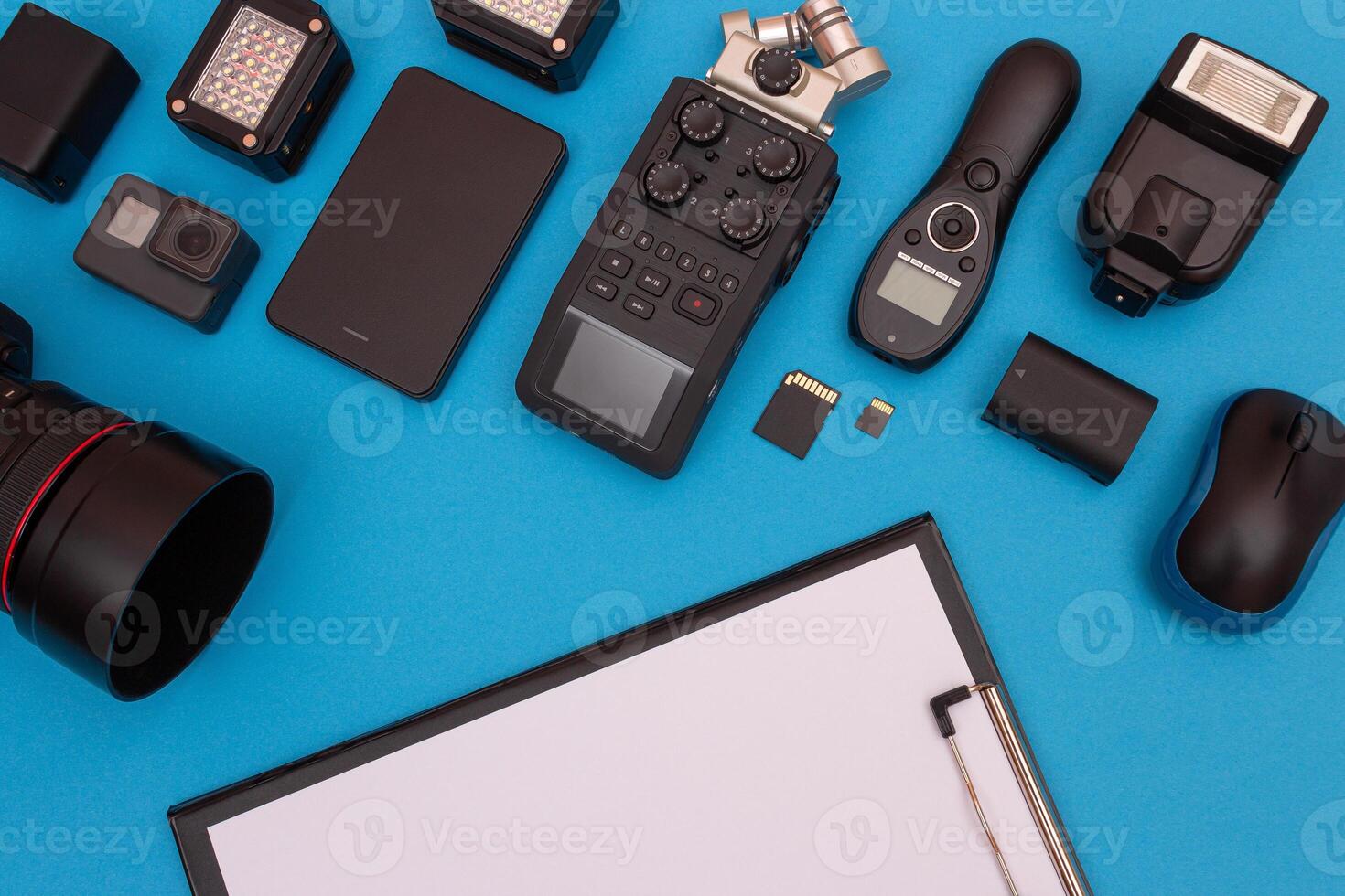 Top View of Photographer's, Videographer's or Blogger's Workplace. Digital Gadgets Lying on Blue Table - Flat Lay photo