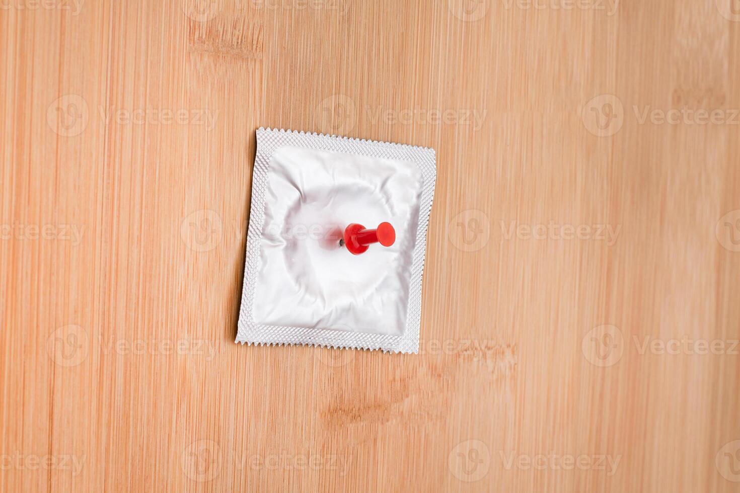 A Joke on Colleagues, Freebie or a Defective Condom - Packaged Latex Condom Pinned to a Wooden Message Board photo