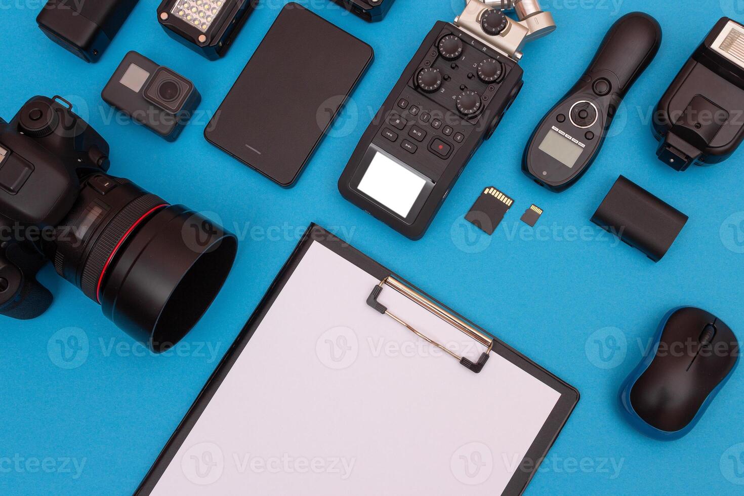 Top View of Photographer's, Videographer's or Blogger's Workplace. Digital Gadgets Lying on Blue Table - Flat Lay photo