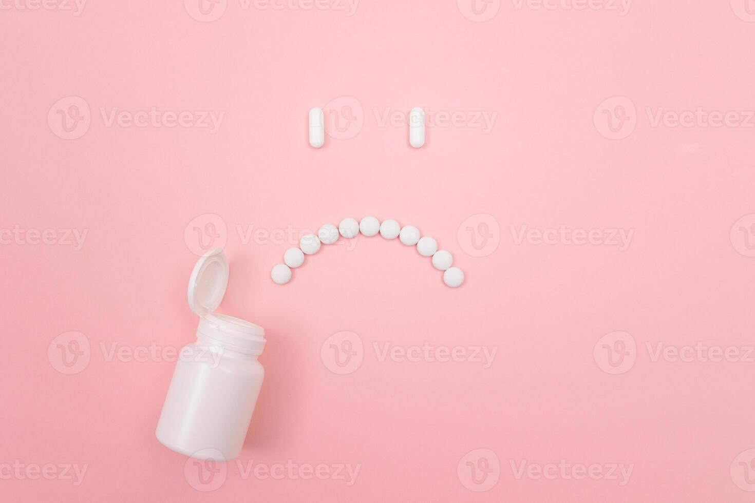 Pharma Harm. Sad Smiley Face Made from White Pills, Lying on Pink Backgrond. Global Pharmaceutical Industry and Medicinal Products photo