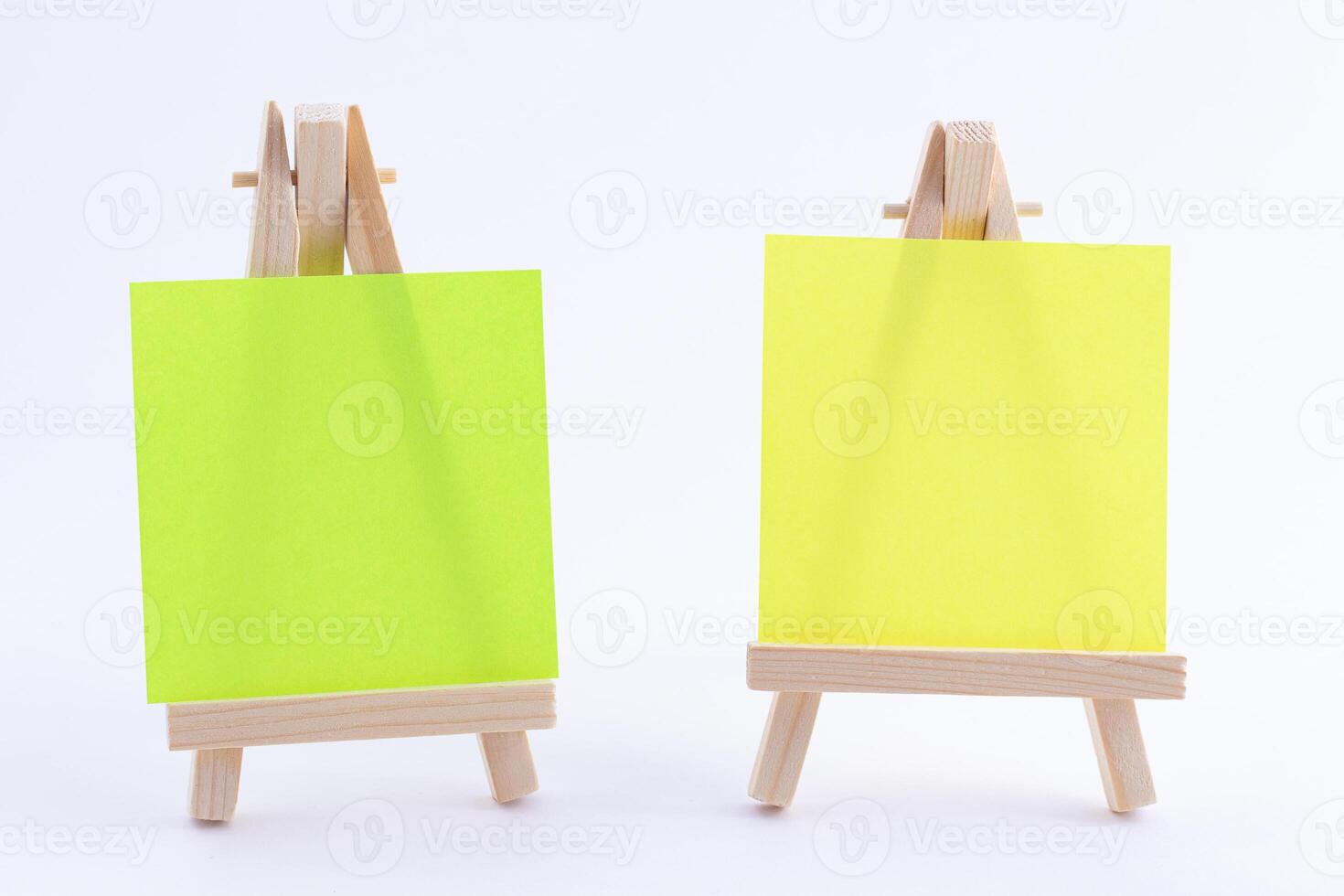 Two Wooden Easels Miniature with Blank Colored Square Canvas or Memo Paper - Mockup. Mini Wooden Stand with Clean Artboard on White Background, Copy Space photo