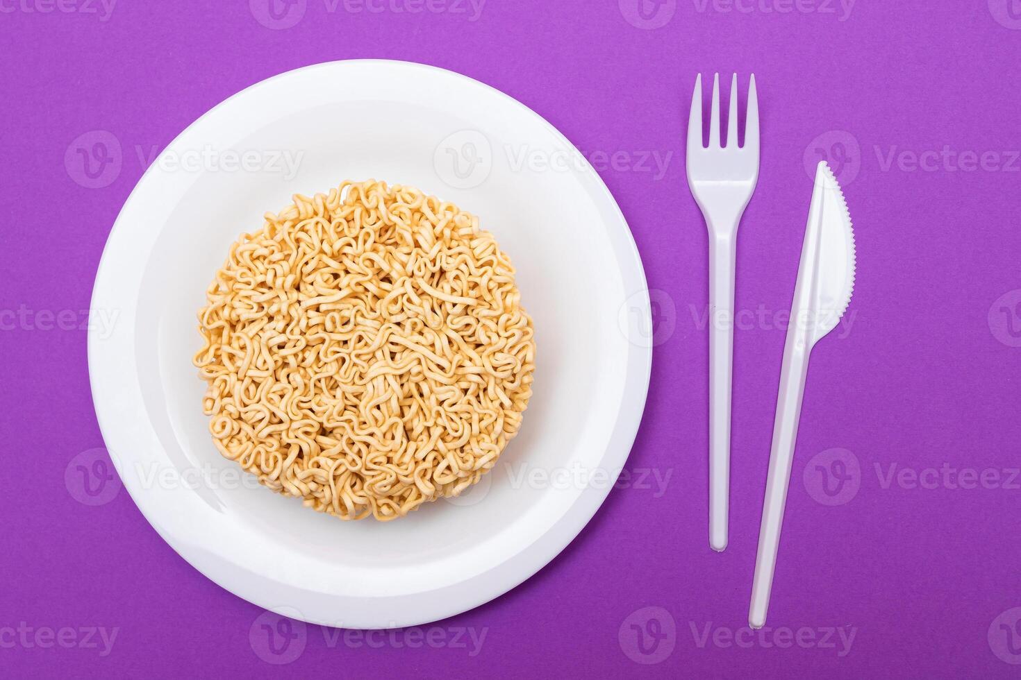 Uncooked Instant Noodles on White Plate. Raw Pasta. Dry Asian Fast Food. Quick Lunch photo