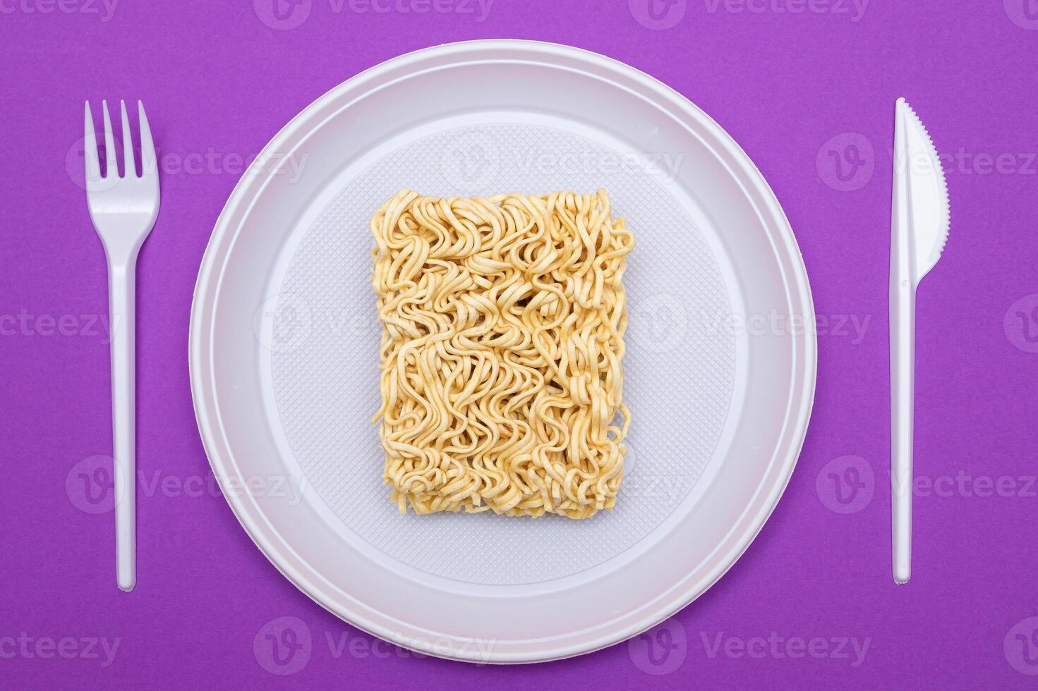 Uncooked Instant Noodles on White Plate. Raw Pasta. Dry Asian Fast Food. Quick Lunch photo