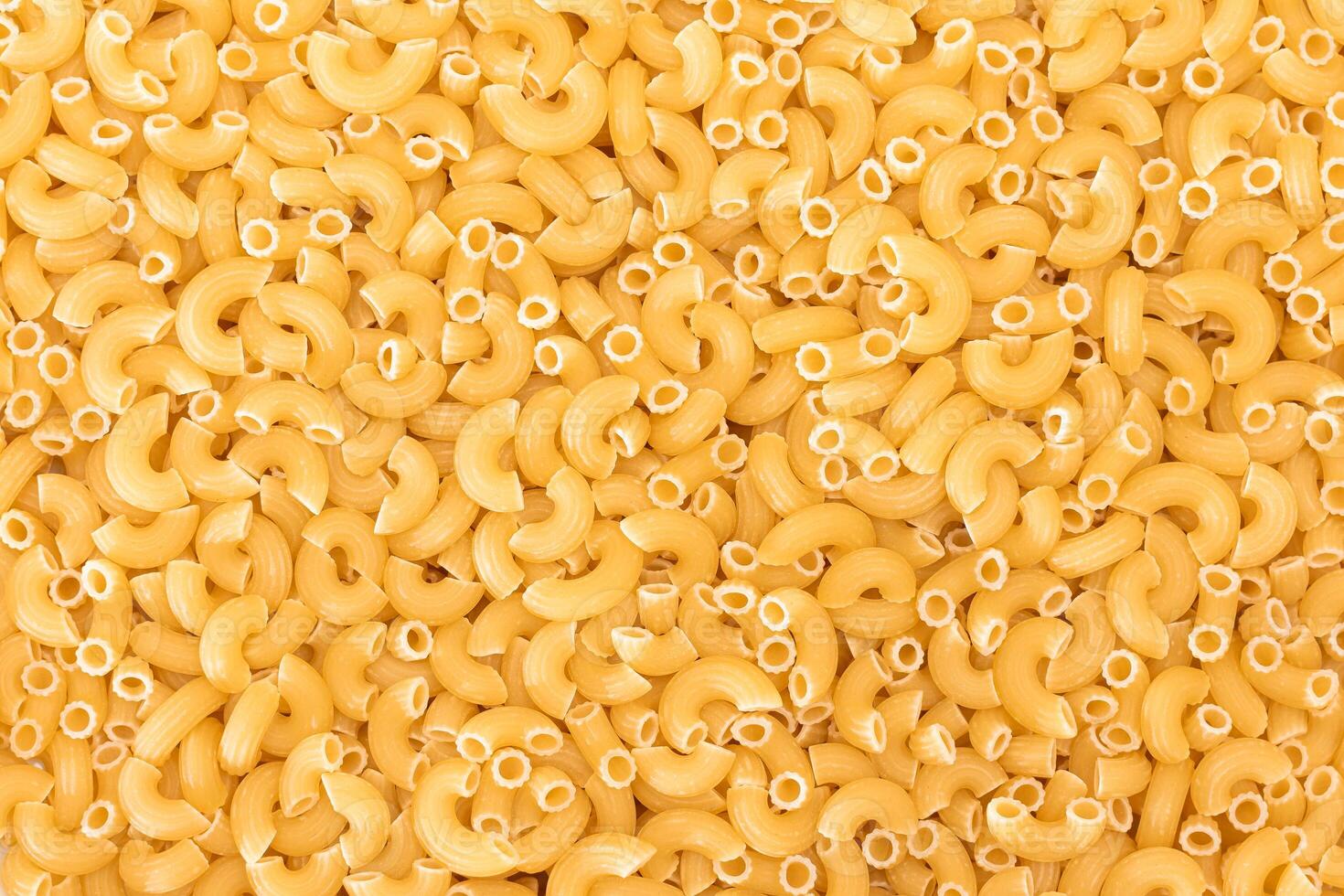 Uncooked Chifferi Rigati Pasta Background. Fat and Unhealthy Food. Classic Dry Macaroni Texture. Italian Culture and Cuisine. Raw Pasta photo