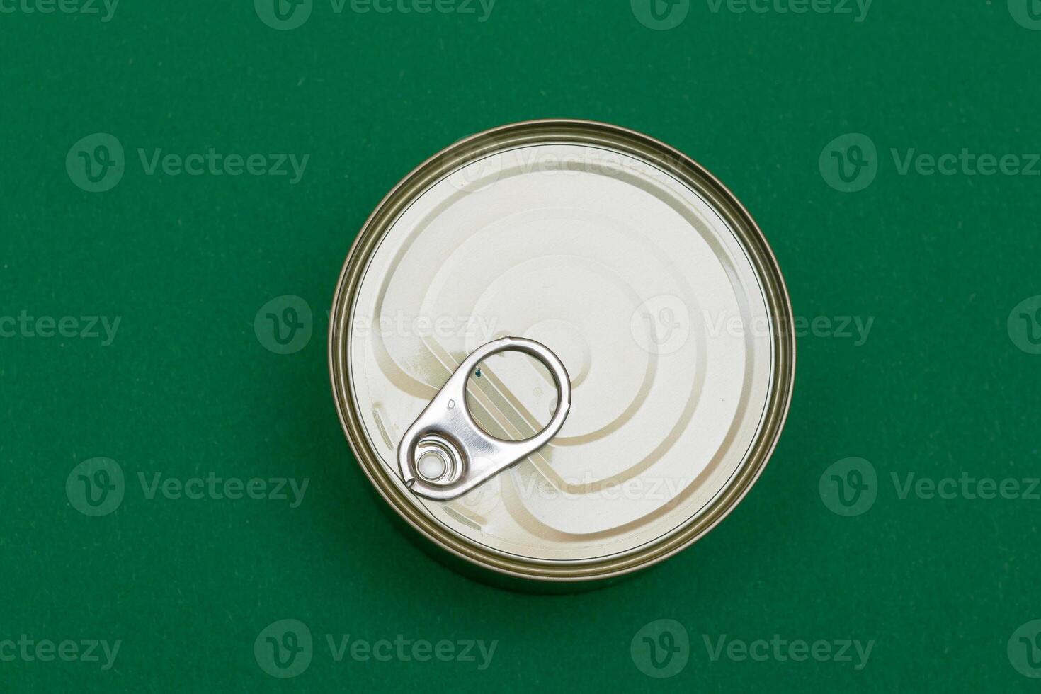 Unopened Tin Can with Blank Edge on Green Background. Canned Food. Aluminum Can for Safe and Long Term Storage of Food. Steel Sealed Food Storage Container photo