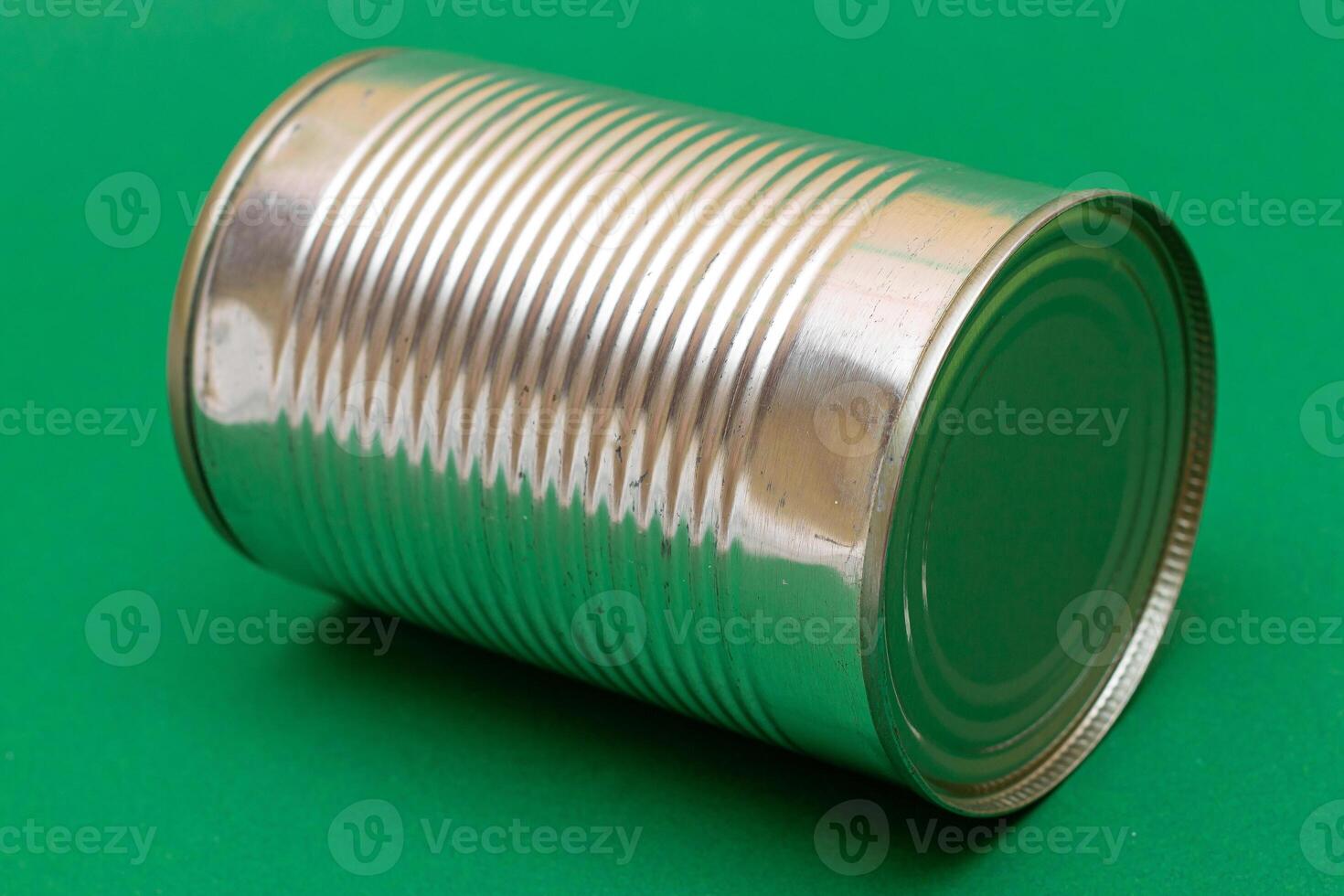 Unopened Tin Can with Blank Edge on Green Background. Canned Food. Aluminum Can for Safe and Long Term Storage of Food. Steel Sealed Food Storage Container photo