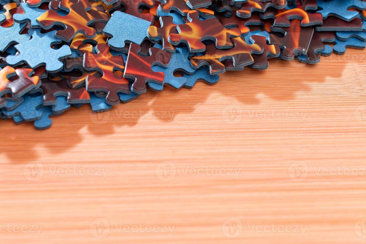 Colorful Pieces of a Mixed Jigsaw Puzzle Lie on the Wooden Table - Strategy and Solving Problem Concept photo