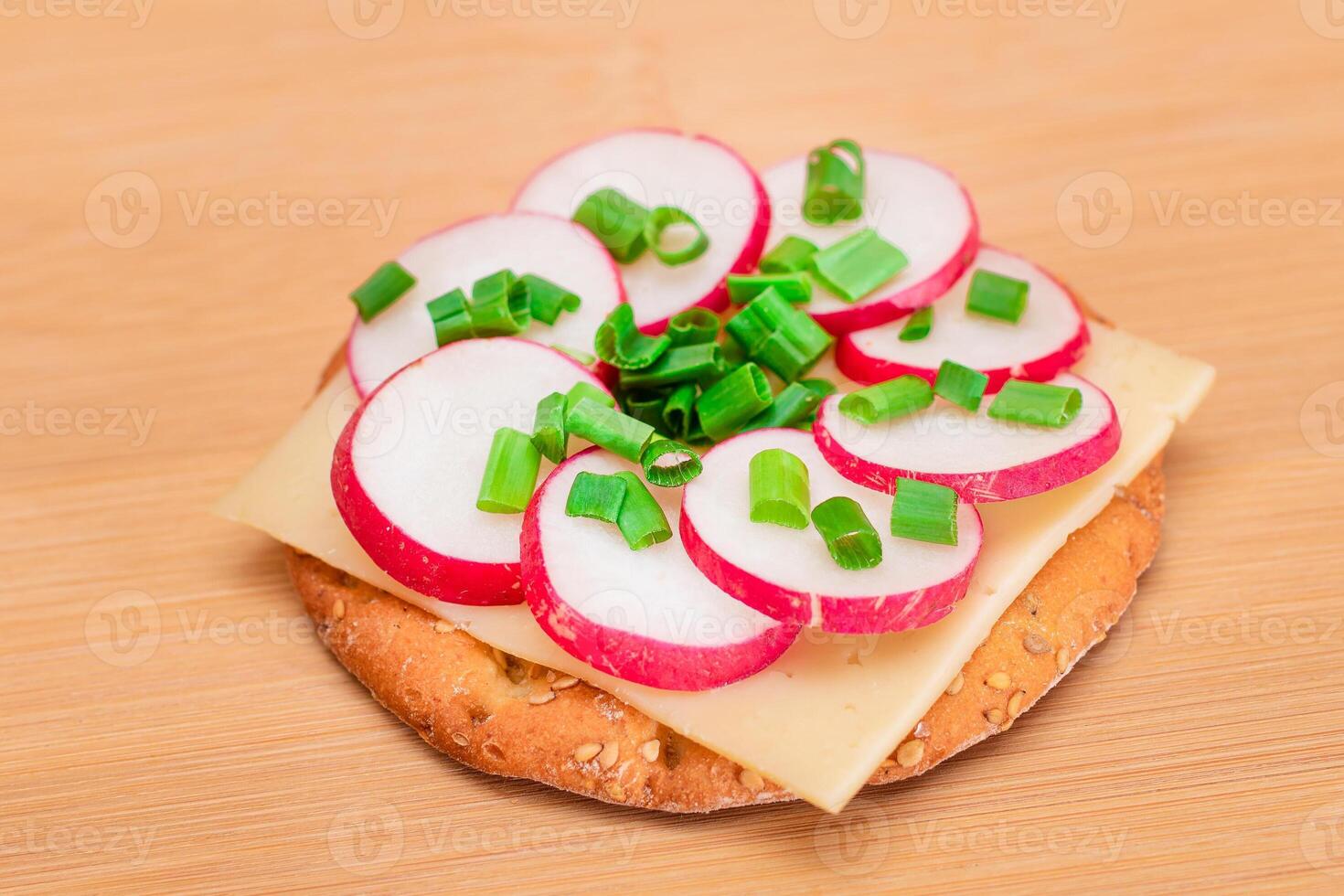 Crispy Cracker Sandwich with Radish, Cheese and Green Onions on Cutting Board. Easy Breakfast. Diet Food. Quick and Healthy Sandwiches. Crispbread with Tasty Filling. Healthy Dietary Snack photo