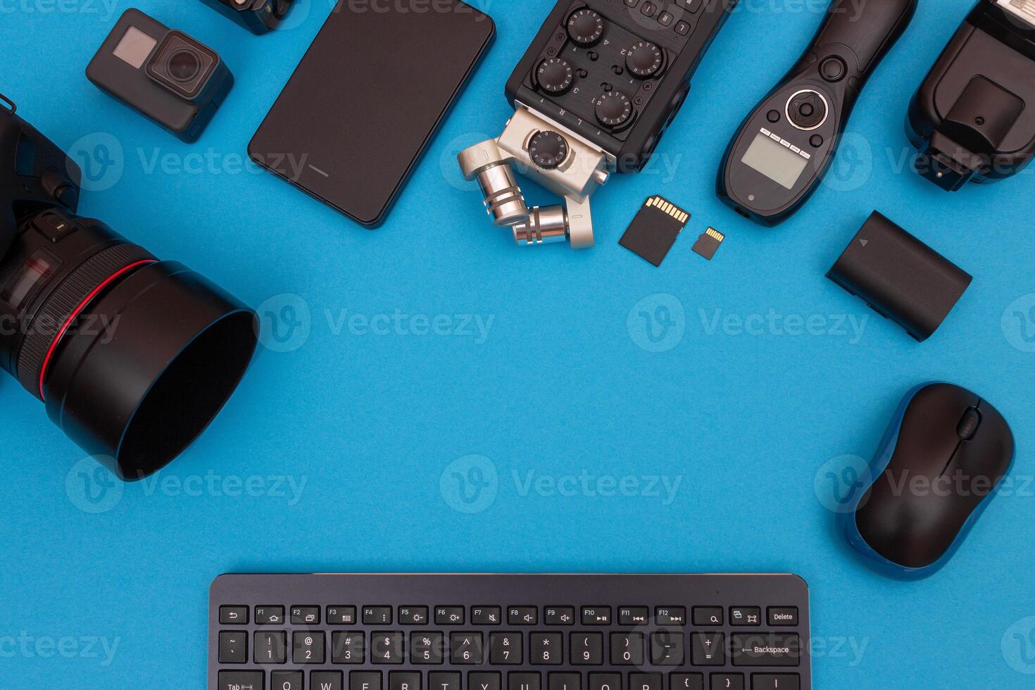 Top View of Photographer's, Videographer's or Blogger's Workplace. Digital Gadgets Lying on Blue Table - Flat Lay photo