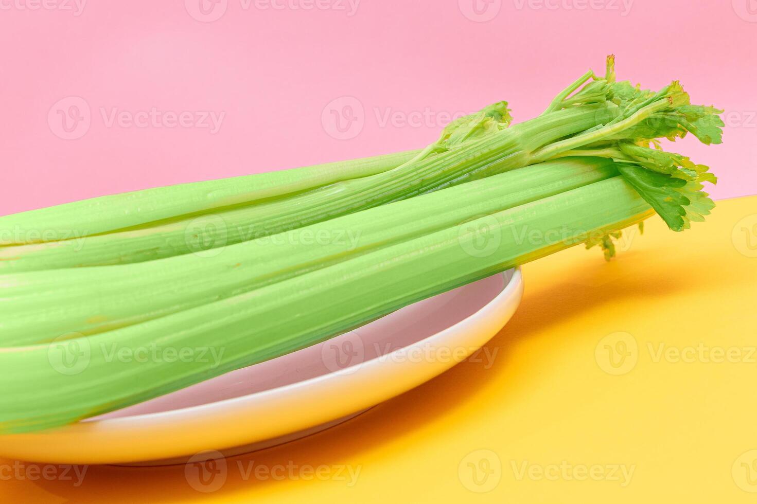 Fresh Celery Stalk on White Dish. Vegan and Vegetarian Culture. Raw Food. Healthy Diet with Negative Calorie Content photo