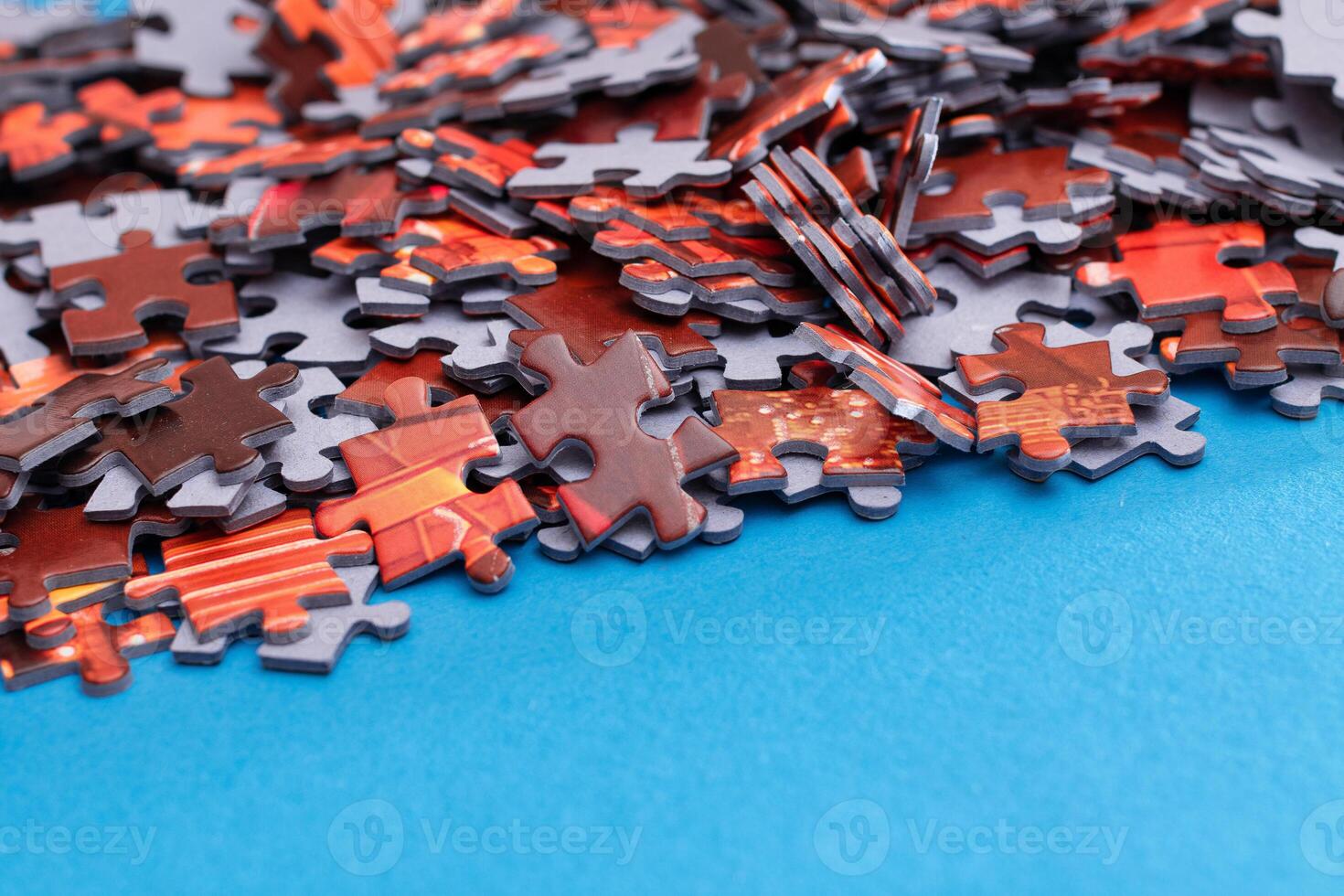 Mixed Pieces of a Colorful Jigsaw Puzzle Lie on the Blue Background - Strategy and Solving Problem Concept photo