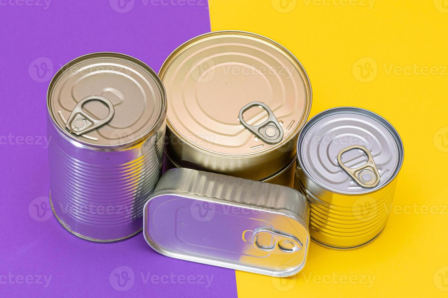 A Group of Stacked Tin Cans with Blank Edges on Split Yellow and Violet Background. Canned Food. Different Aluminum Cans for Safe and Long Term Storage of Food. Steel Sealed Food Storage Containers photo