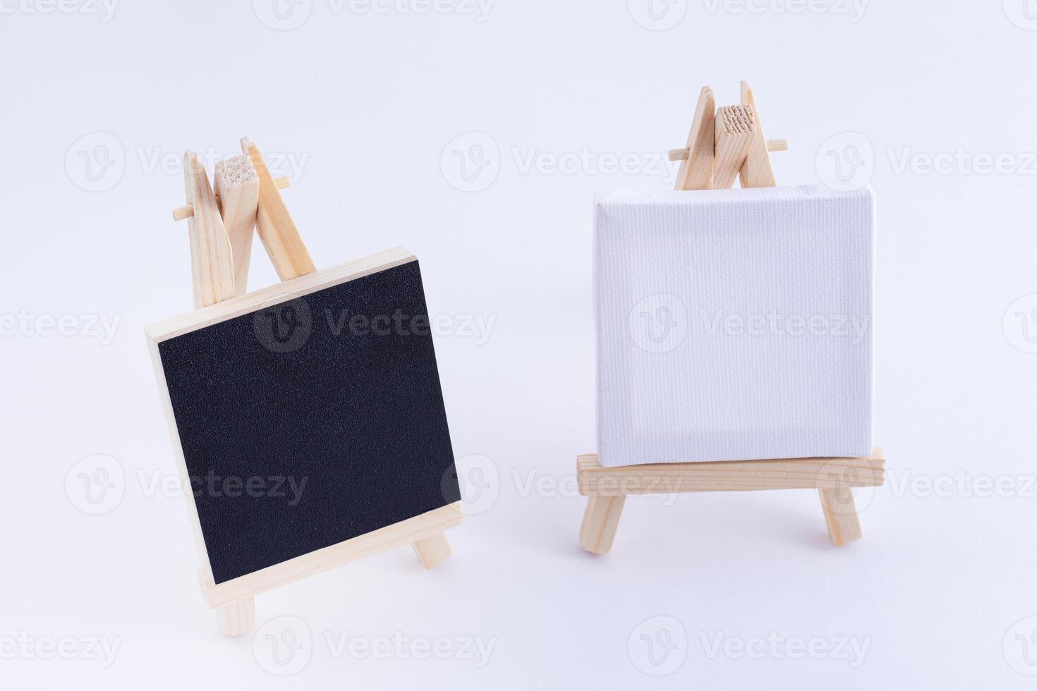 Two Wooden Easels Miniature with Blank Black and White Square Canvas for Artists and Painters - Mockup. Mini Wooden Stand with Clean Artboard on White Background, Copy Space photo