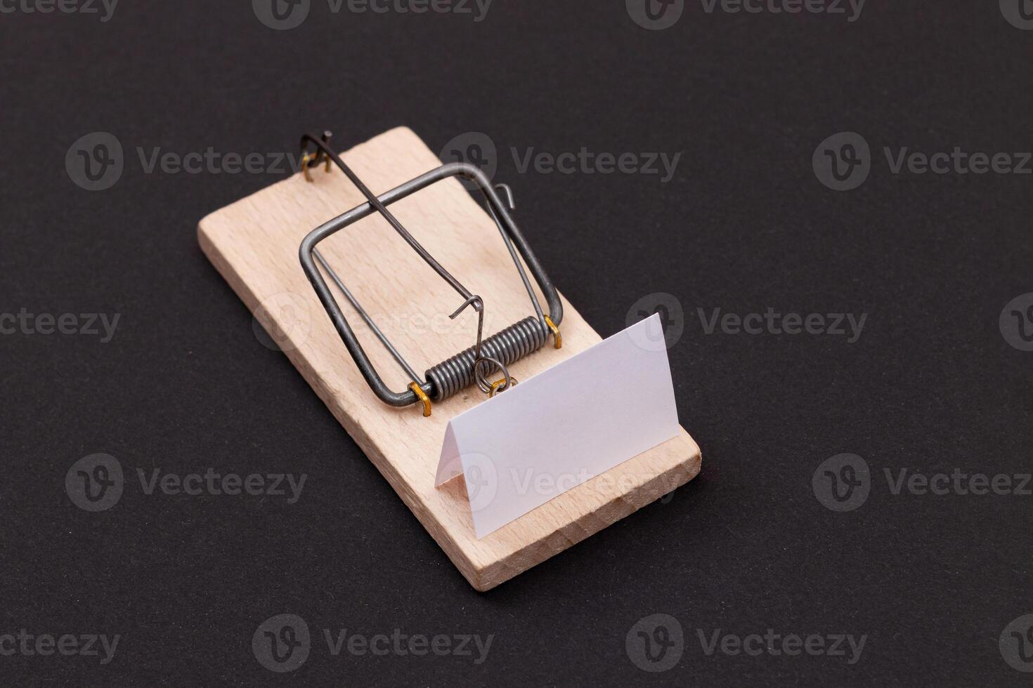 Blank White Sheet of Paper in Wooden Mousetrap - Template. Small Memo Paper in Mouse Trap on Black Background photo