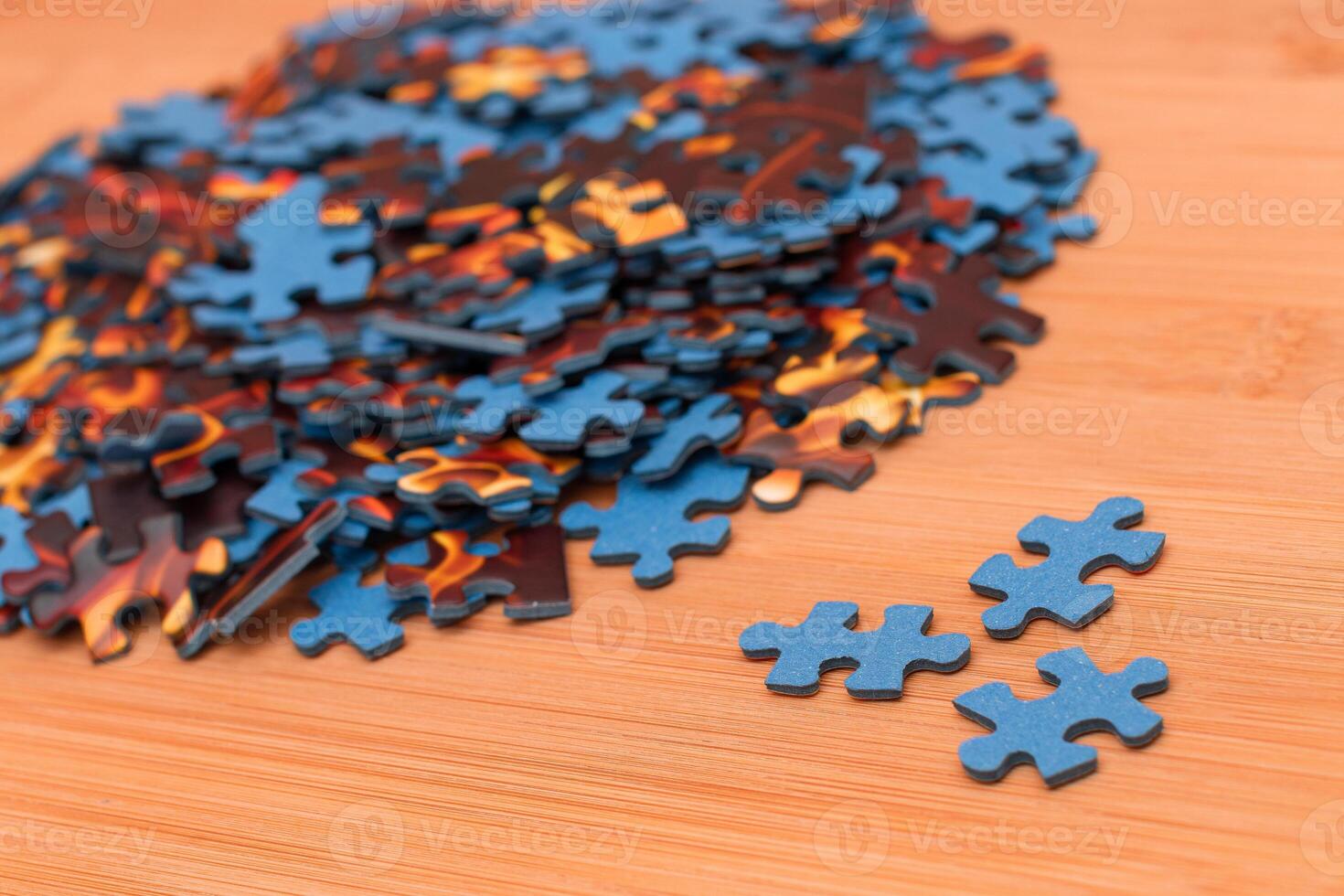 Colorful Pieces of a Mixed Jigsaw Puzzle Lie on the Wooden Table - Strategy and Solving Problem Concept photo