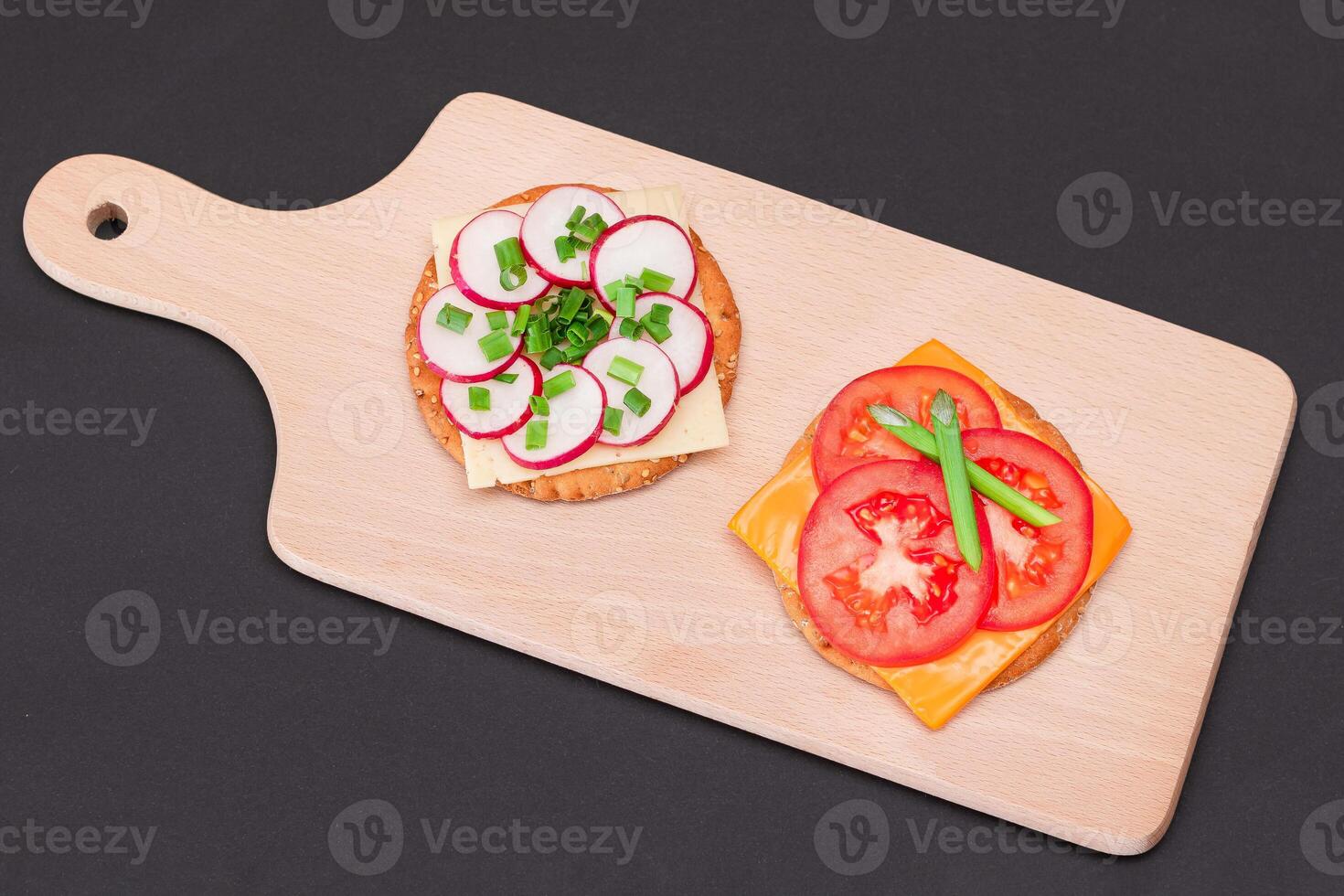 Different Cracker Sandwiches with Tomato, Cucumber, Radish and Cheese on Cutting Board. Easy Breakfast. Diet Food. Quick and Healthy Sandwiches. Crispbread with Tasty Filling. Healthy Dietary Snack photo
