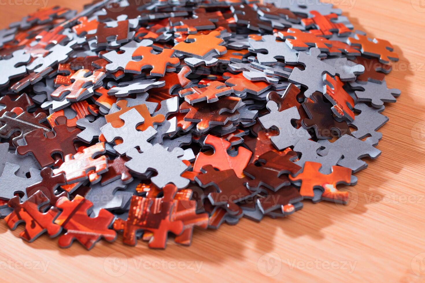 Colorful Pieces of a Mixed Jigsaw Puzzle Lie on the Wooden Table - Strategy and Solving Problem Concept photo
