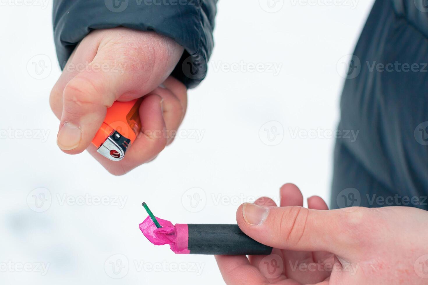 Guy Sets Fire to the Flash Noise Firecracker Outdoors in Winter at Daytime. Loud and Dangerous New Year's Entertainment. Hooliganism with Pyrotechnics. Noise of Petards in Public Places photo
