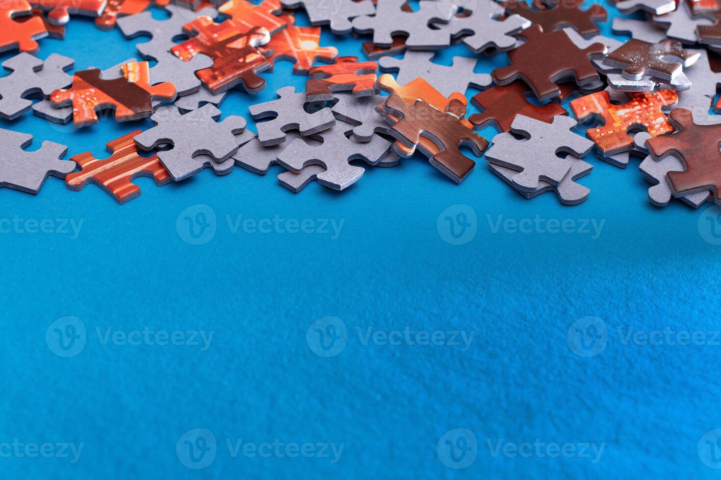Mixed Pieces of a Colorful Jigsaw Puzzle Lie on the Blue Background With Copy Space - Strategy and Solving Problem Concept photo