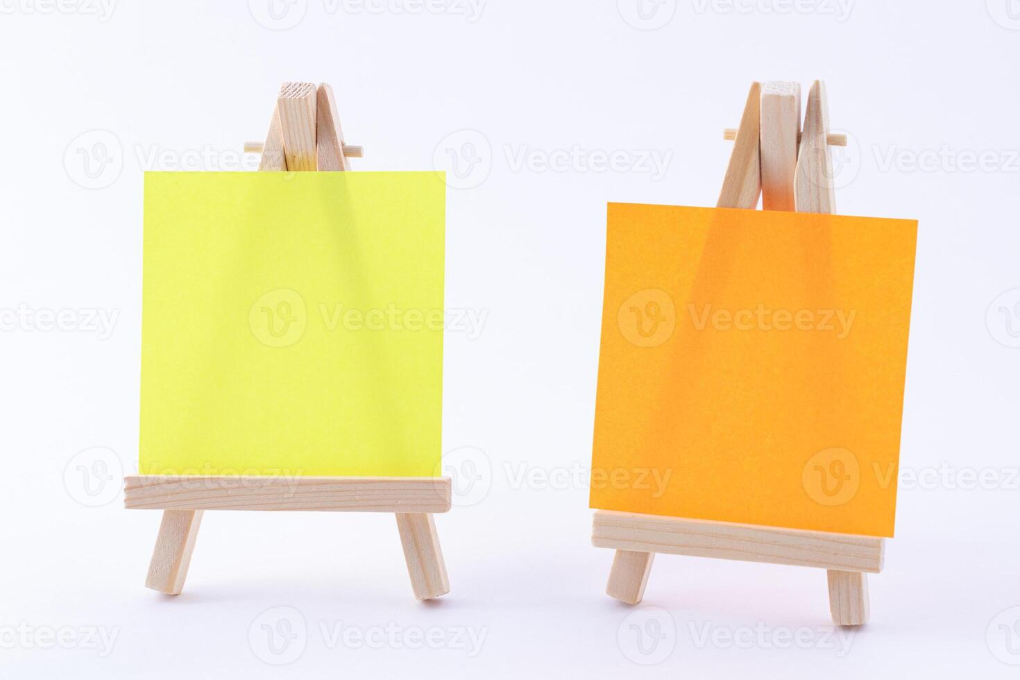 Two Wooden Easels Miniature with Blank Colored Square Canvas or Memo Paper - Mockup. Mini Wooden Stand with Clean Artboard on White Background, Copy Space photo