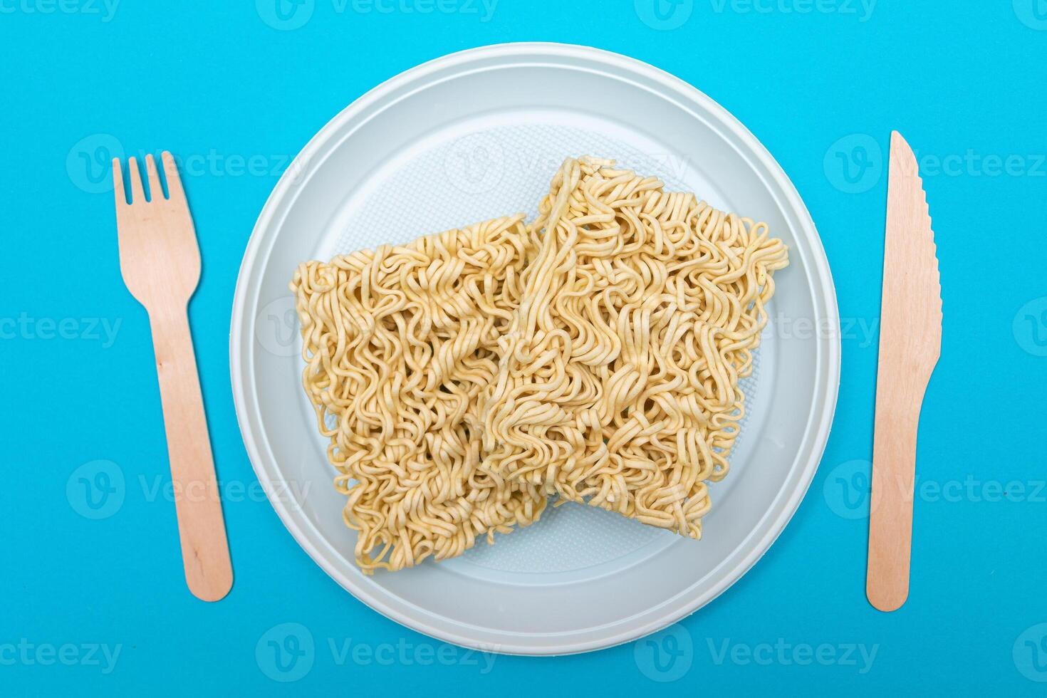 Uncooked Instant Noodles on White Plate. Raw Pasta. Dry Asian Fast Food. Quick Lunch photo