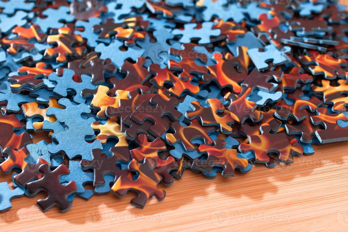 Colorful Pieces of a Mixed Jigsaw Puzzle Lie on the Wooden Table - Strategy and Solving Problem Concept photo