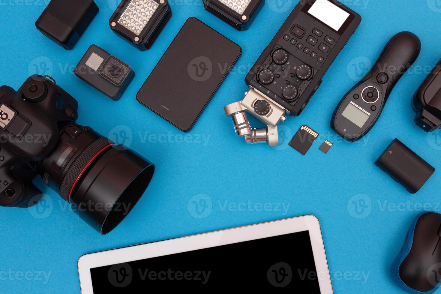 Top View of Photographer's, Videographer's or Blogger's Workplace. Digital Gadgets Lying on Blue Table - Flat Lay photo