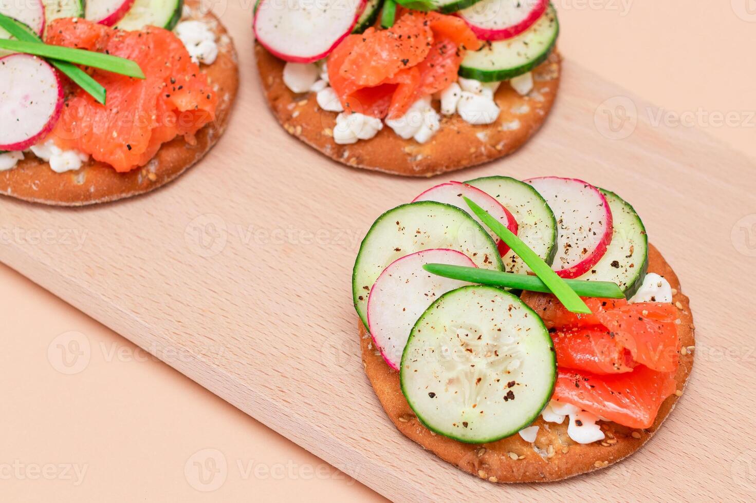 Crispy Cracker Sandwiches with Fresh Salmon, Cucumber, Radish, Cottage Cheese and Green Onions. Easy Breakfast. Quick and Healthy Sandwiches. Crispbread with Tasty Filling. Healthy Dietary Snack photo